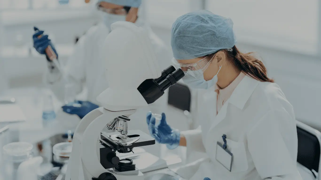 Professional VOC testing and air quality analysis: A scientist using a high-powered microscope to identify chemical contaminants and volatile organic compounds.