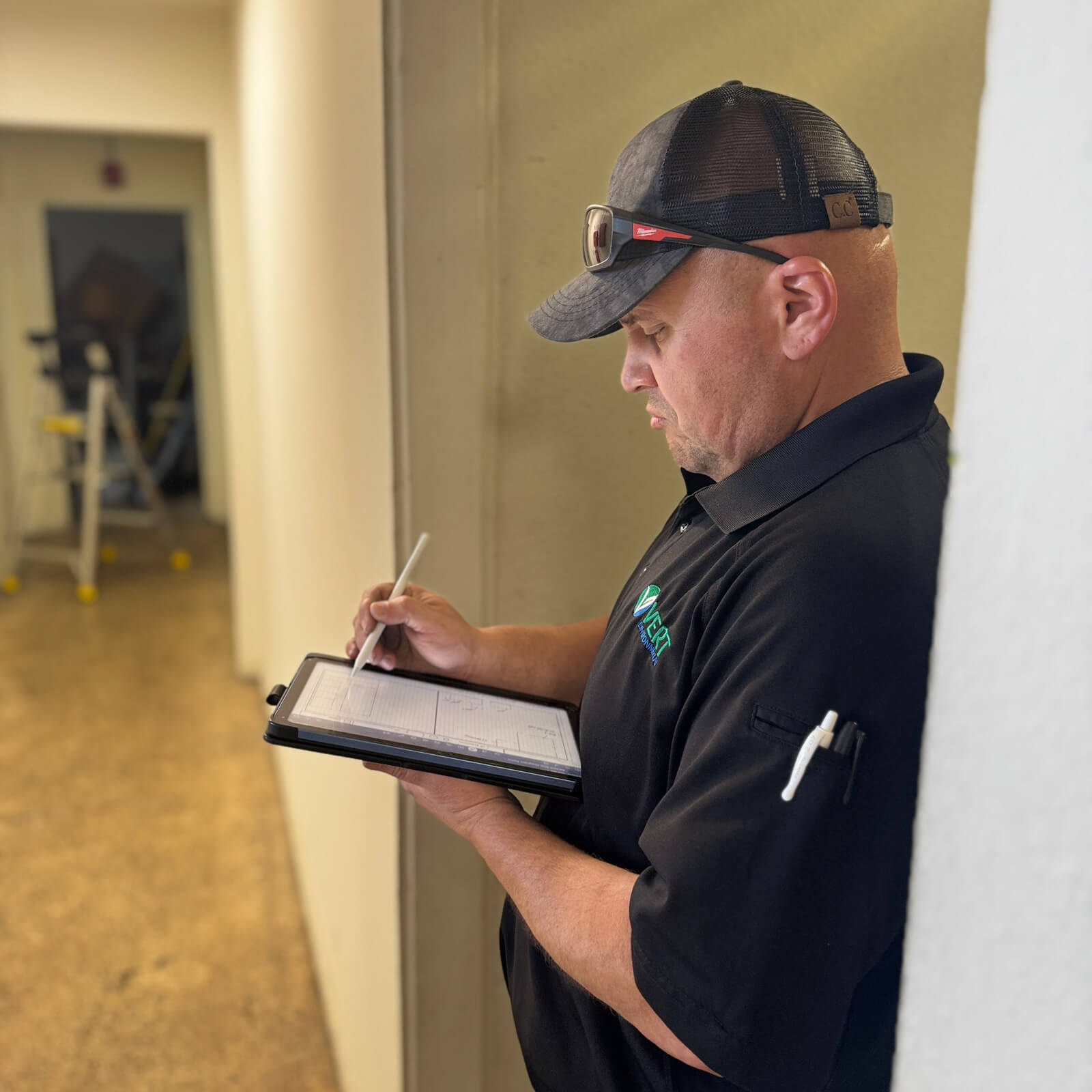 Technician recording site survey data on a tablet during an environmental hazard assessment for Clear Tech Pools.